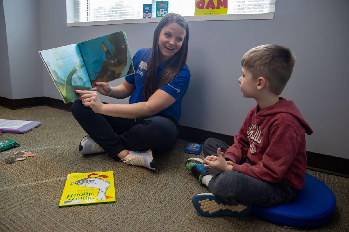 Client playing a board game with a clinician